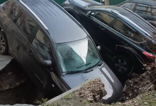 У центрі Києва під асфальт провалилися одразу декілька авто (фото)
